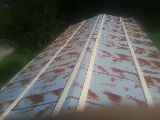 Rusted metal roof panels with new wood purlins before replacement — Storm Damage Roof Repair in Hanson by Roofing Brothers