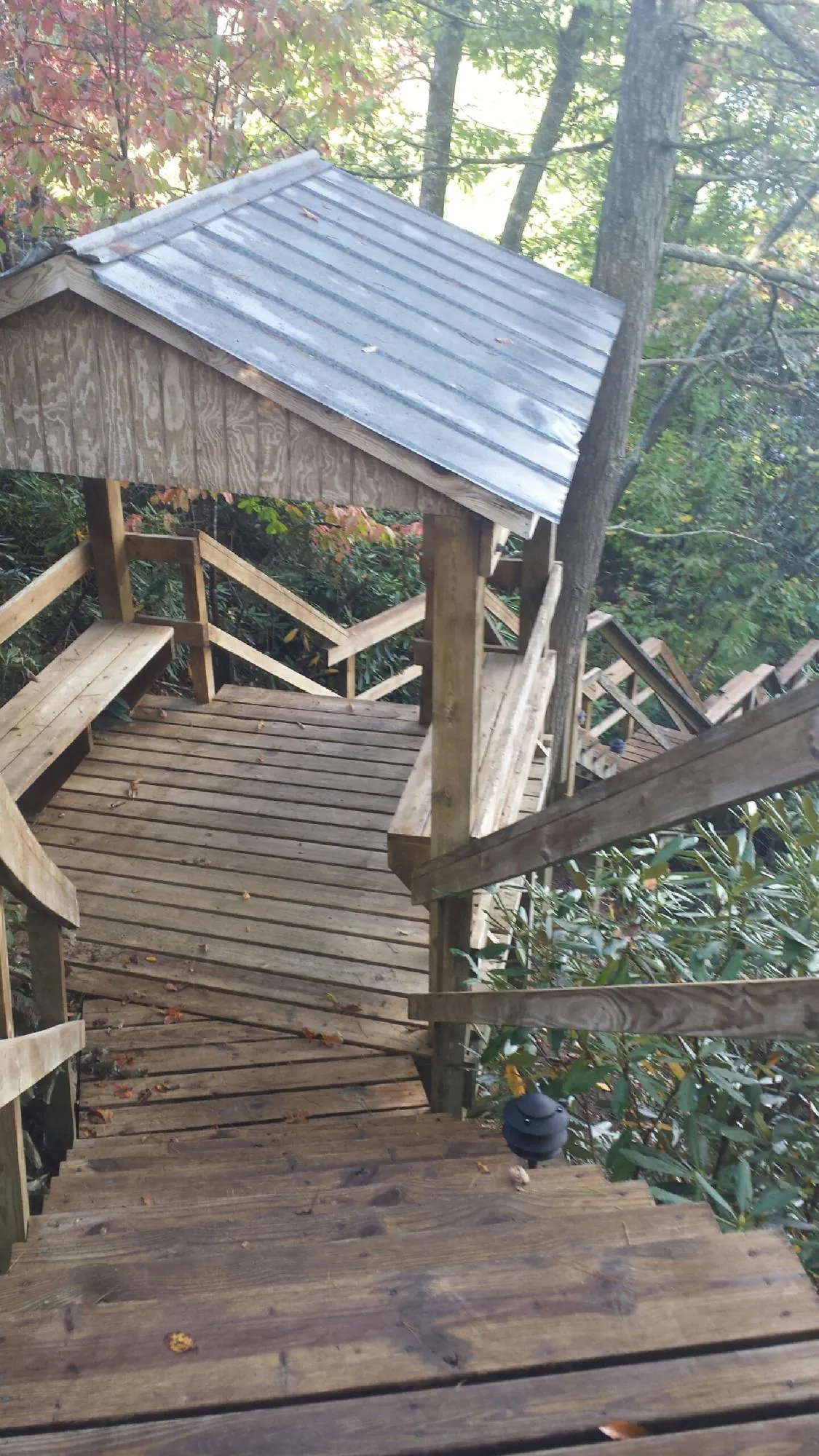 Metal roofed shelter over wooden steps on a wooded walkway — Skylight Repair & Installation work by our crew in Hanson
